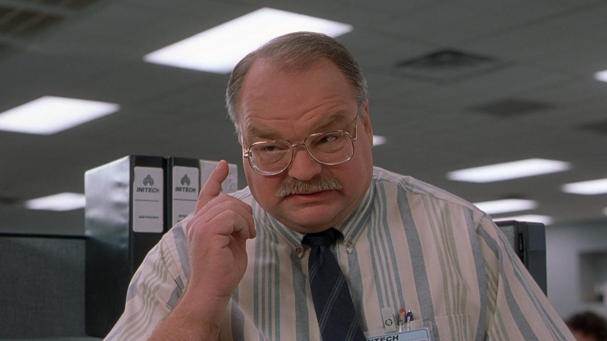 Richard Riehle giving the thinking sign in a still from Office Space.
